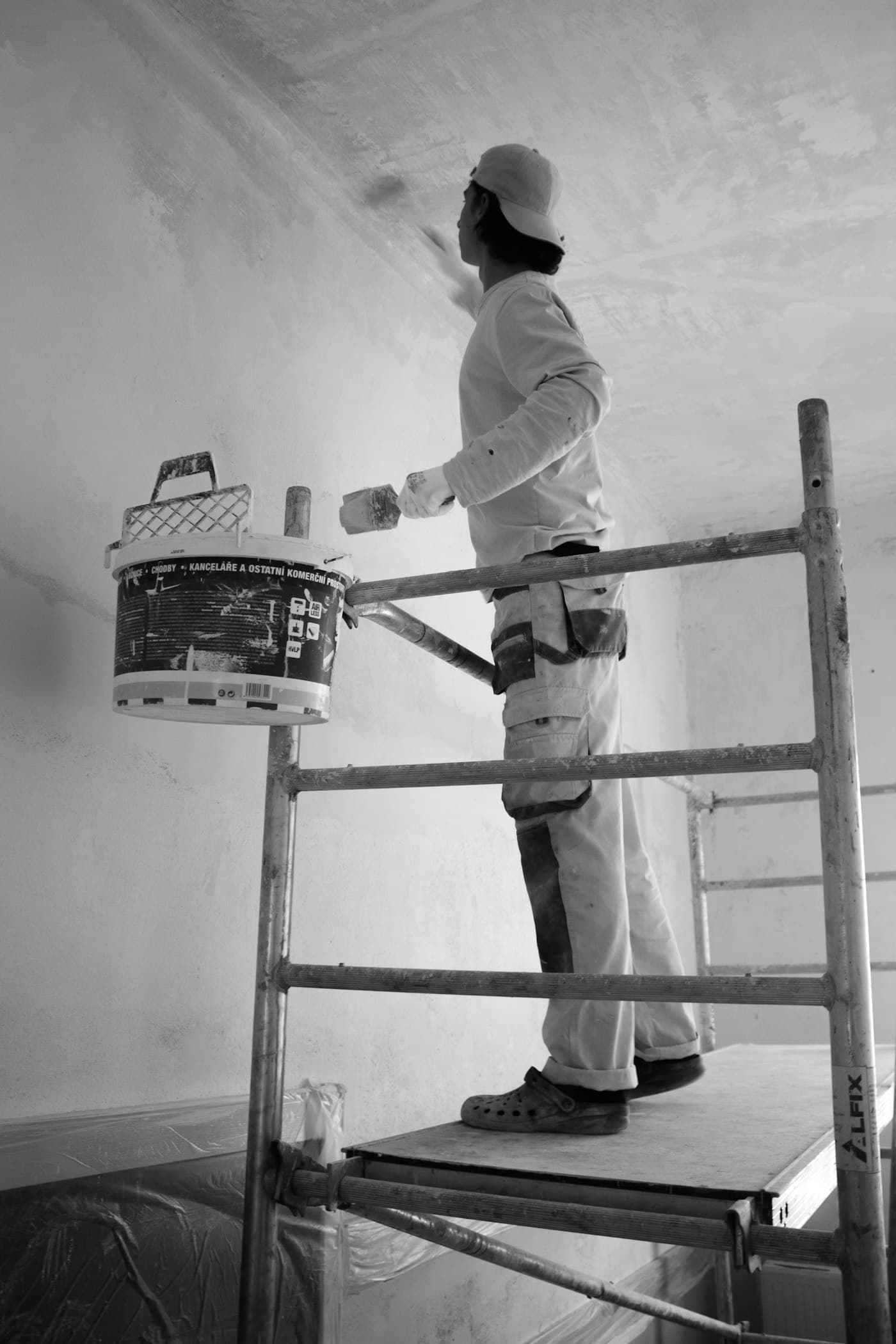 Handwerker beim Streichen einer Wand – Sinnbild für Sanierungsmaßnahmen nach dem Immobilienkauf